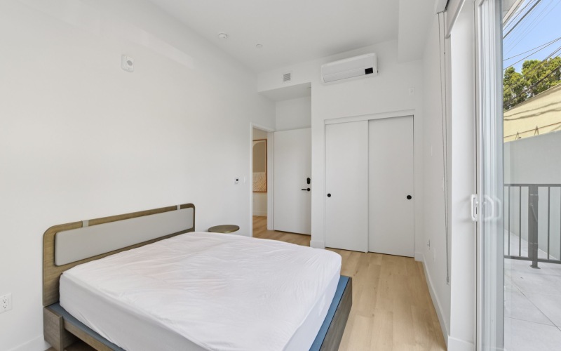 a bedroom with a bed and wood floors