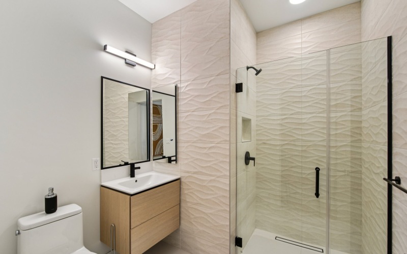 a bathroom with a sink, shower and toilet